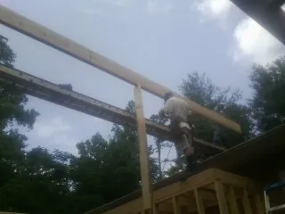 Carpenter setting a ridge beam over a new addition frame — Ice Dam Removal by Roofing Brothers in Sioux Center