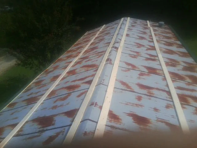 Rusted metal roof panels with new wood purlins before replacement — Storm Damage Roof Repair in Sioux Center by Roofing Brothers
