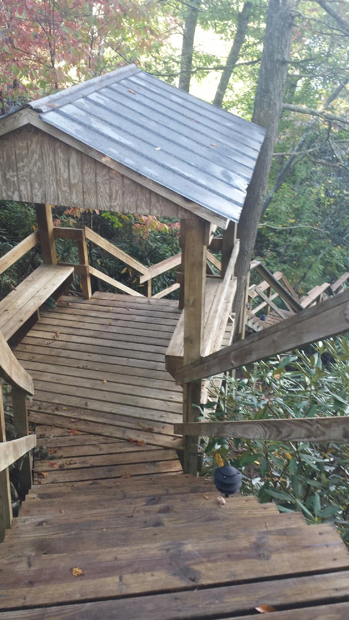 Metal roofed shelter over wooden steps on a wooded walkway — Skylight Repair & Installation work by our crew in Sioux Center