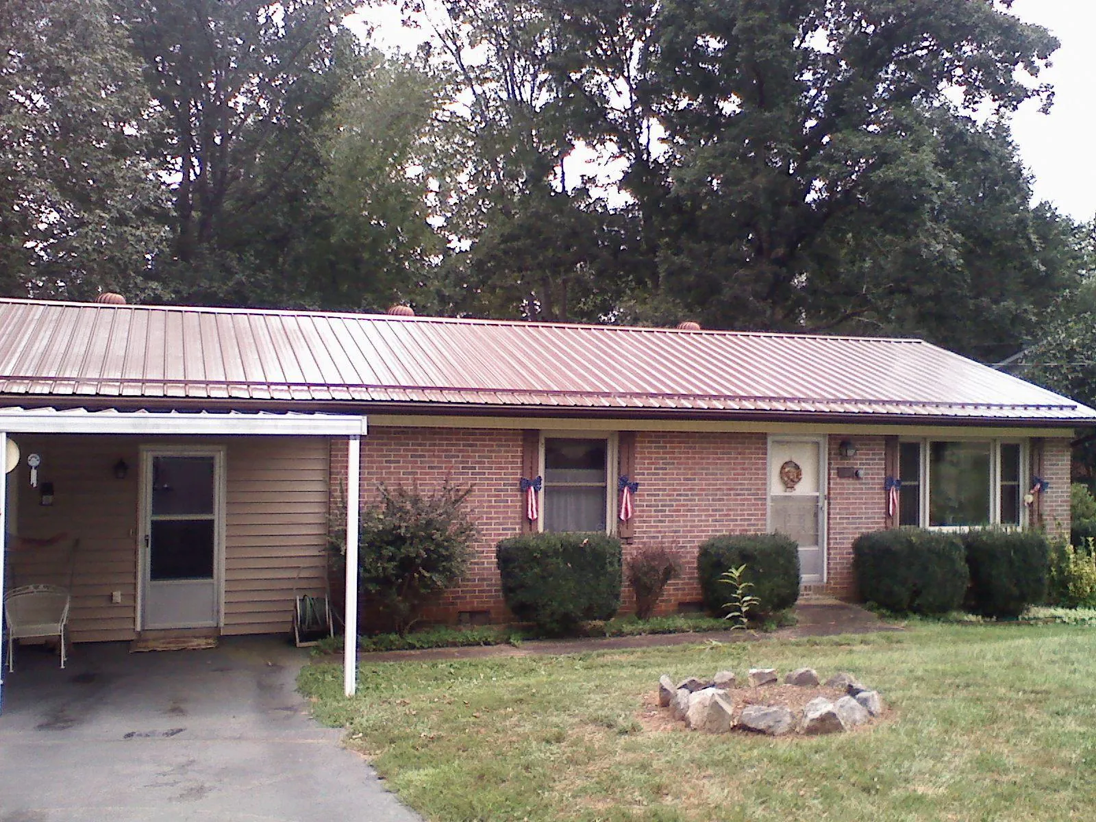 Bronze metal roof and carport on a brick ranch home — Roof Repair work by our crew in Sioux Center